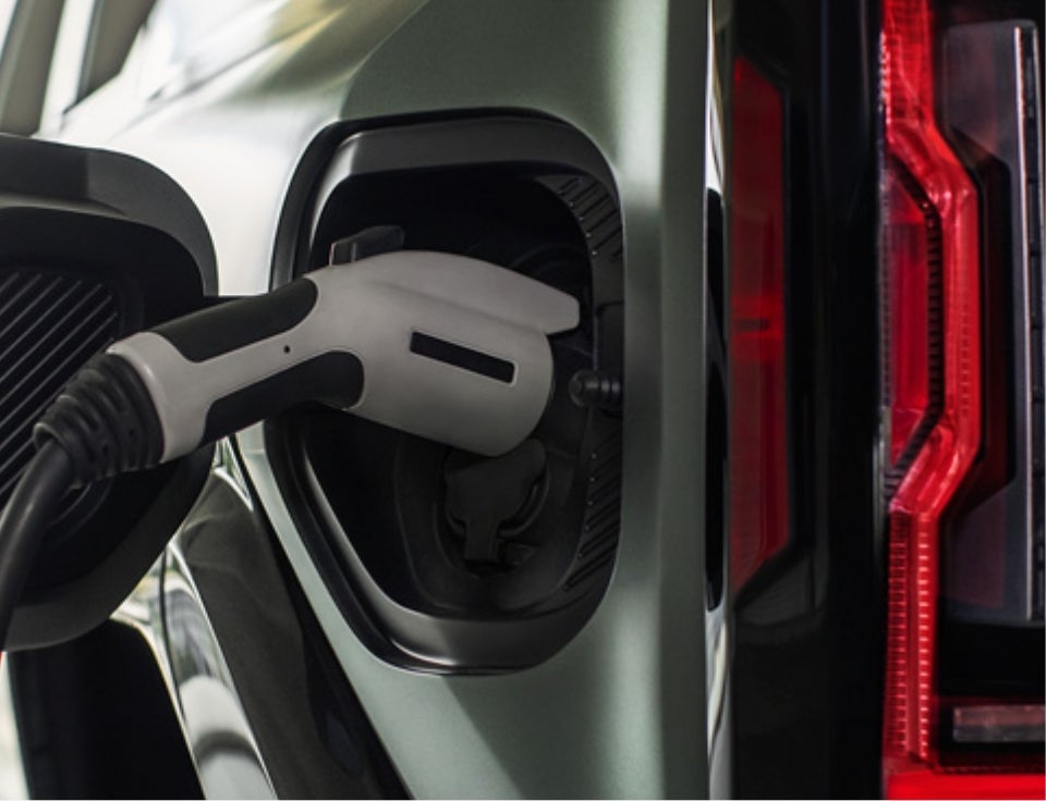 Close up of charging port with charger plugged in on a GMC Hummer EV SUV - Karl GMC of Marshalltown in Marshalltown IA